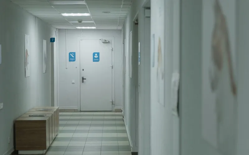 Quiet, spotless medical facility hallway held to clinical cleaning standards