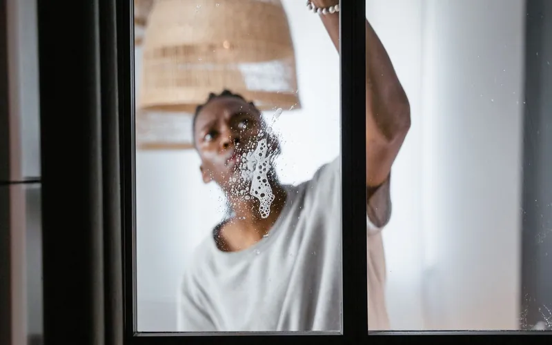 Professional cleaning an interior glass window until streak-free